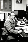 Ron Crecelius talks on the phone at his desk