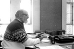 Man in sweater works at his desk