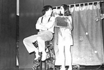 Male Sits on Stool and Looks at Female Holding Prop by George Fox University Archives