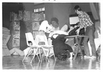 Performers shove others and fall to ground on stage by George Fox University Archives