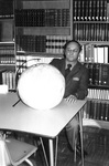 Ron Crecelius sits at table with globe by George Fox University Archives