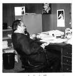 Ron Crecelius talks on the phone at his desk by George Fox University Archives
