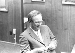 Ron Crecelius smiles at small piece of paper by George Fox University Archives