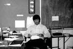 Barry Hubbell sits at desk reading a paper