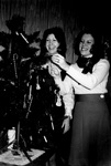 Staff members decorate office Christmas tree by George Fox University Archives
