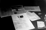 Desk with George Fox newsletters spread out by George Fox University Archives
