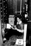 Staff member looks at files from filing cabinet on the floor by George Fox University Archives