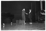 Woman in black shakes hands with boy in suit jacket by George Fox University Archives