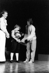 Young actor holds object while older actor assists by George Fox University Archives