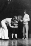 Woman bends down to wipe down young boy; man stands nearby by George Fox University Archives