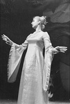 Actress in dress holds hands out and looks to side by George Fox University Archives