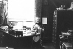 Ron Crecelius sits at his desk by George Fox University Archives