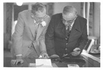 Two Men Looking at Old Photo Albums at a Class Reunion by George Fox University Archives