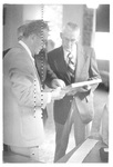 Men Looking at Photos at a Class Reunion by George Fox University Archives