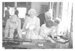 People Looking at Photo Albums at a Class Reunion by George Fox University Archives
