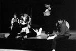 Students hang out on stage; male poses for photo by George Fox University Archives