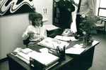 Susie McCarty sits at her desk by George Fox University Archives