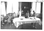 People Sitting on Couches and Talking at an Alumni Reception by George Fox University Archives